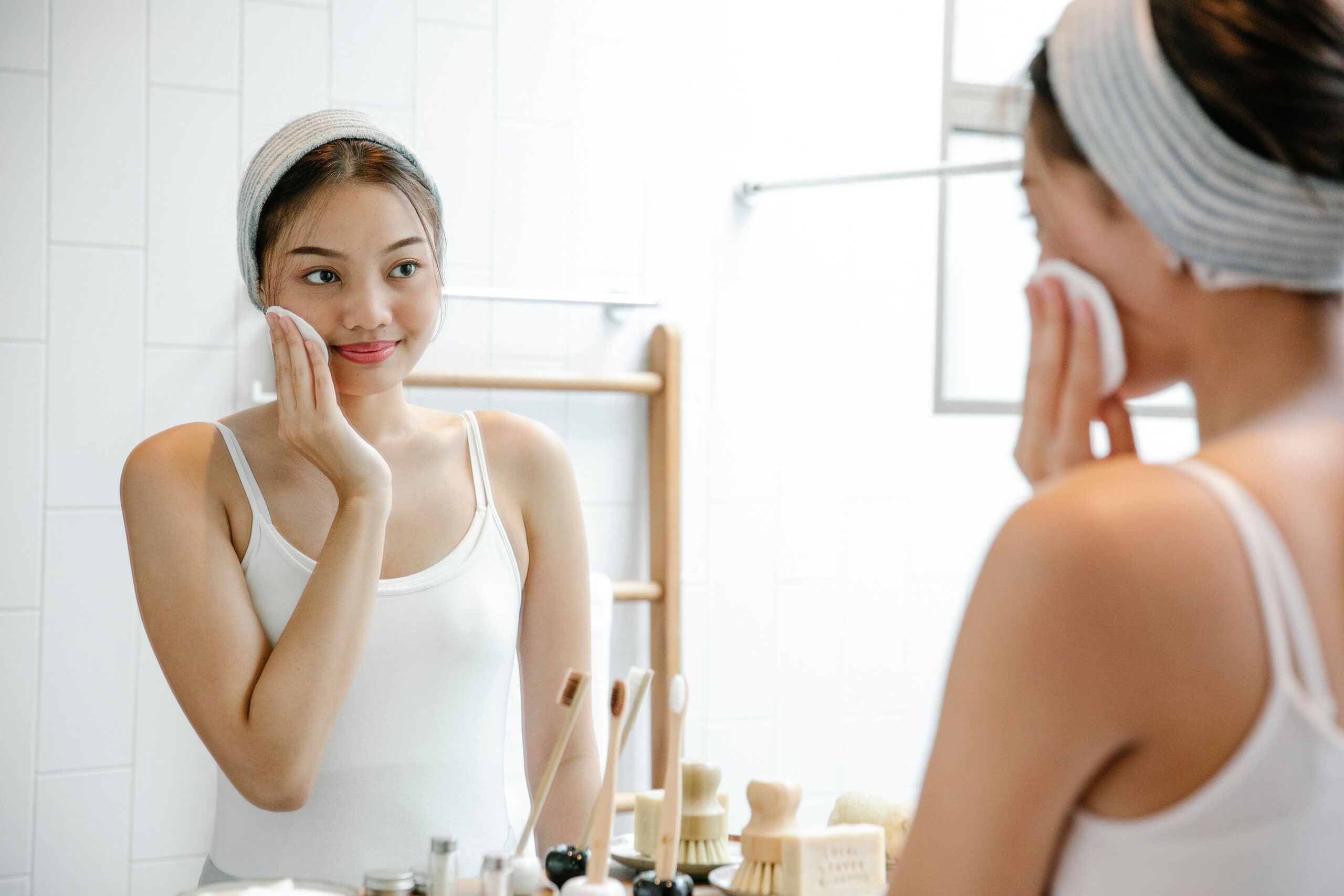Asian lady cleaning face with cotton pad